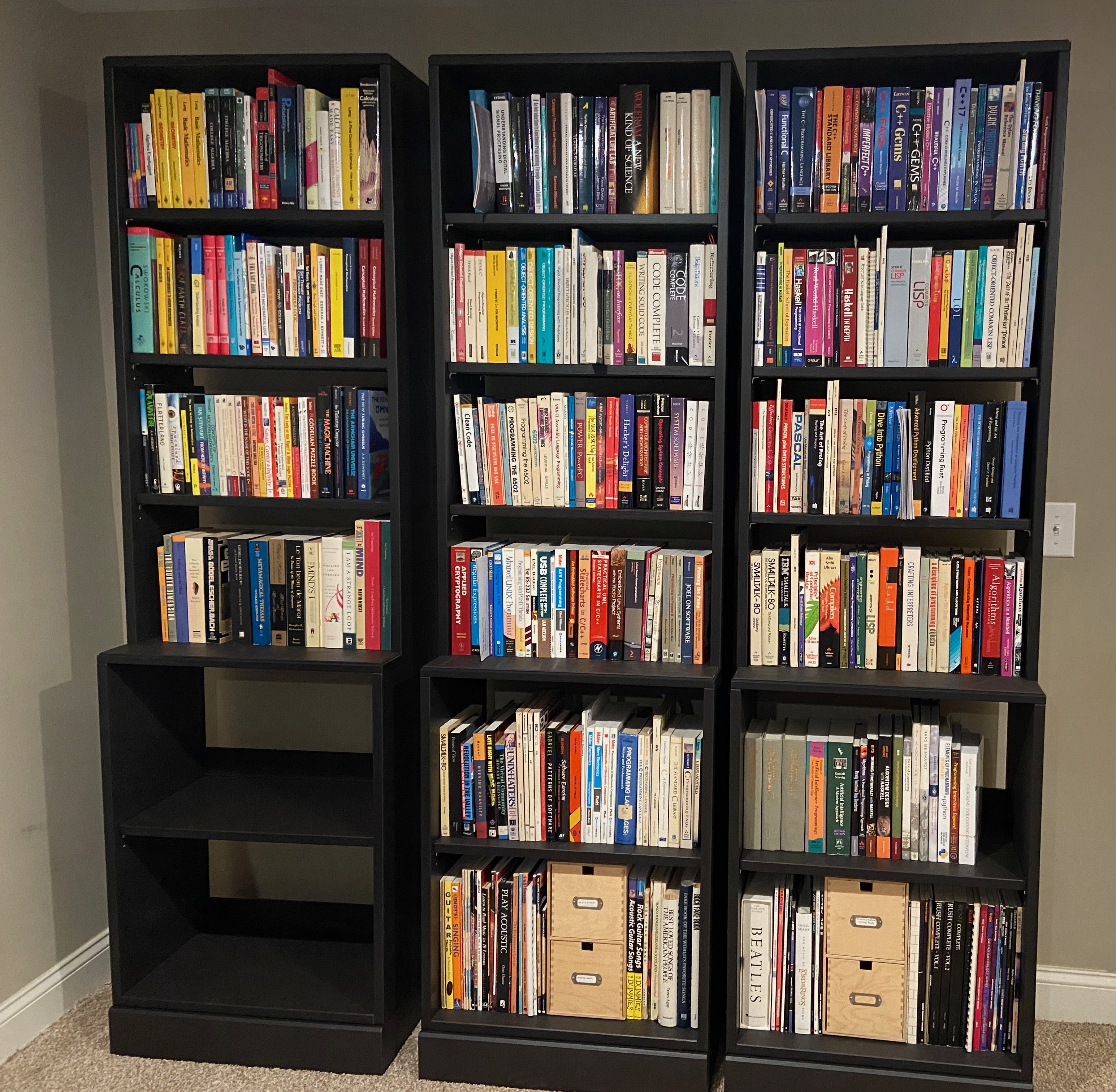 three tall brown bookcases in a row, filled with books